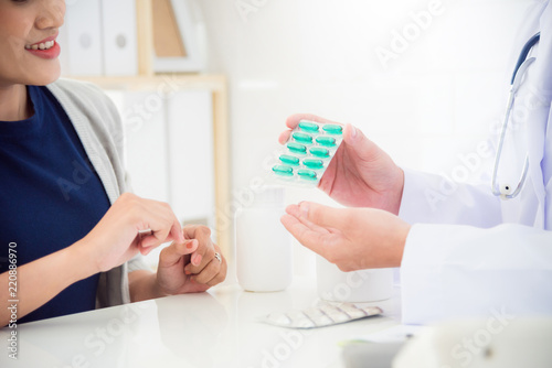 Doctor explain medication to female patient in clinic
