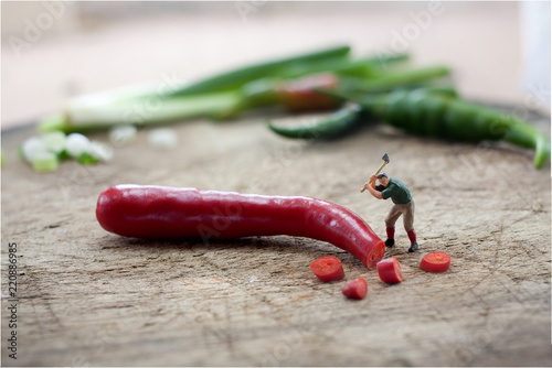 Miniature figure  Workers are chopping red pepper with axe .