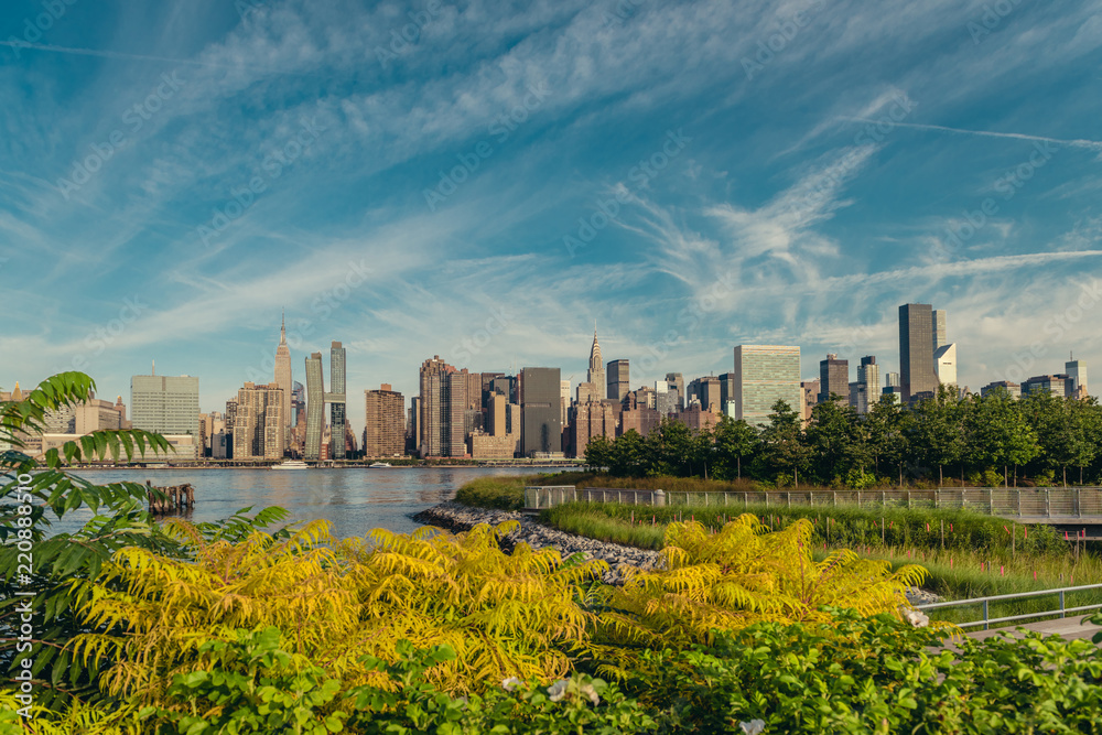Naklejka premium Manhattan midtown skyline with lots of greens from Long Island City in early summer morning