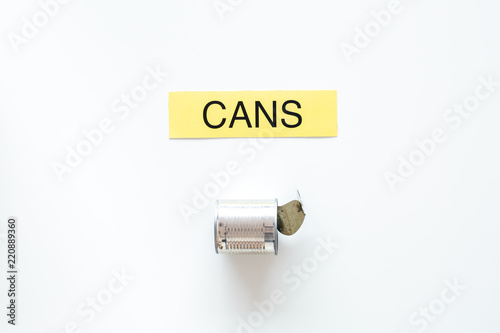 Types of matherial for reycle and reuse. Metal can near printed word cans on white background top view copy space photo