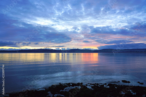 Dramatic colorful blue and orange sunset over Lake Taupo in New Zealand