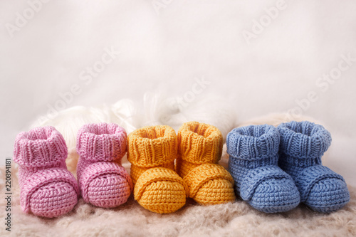 pregnancy concept, Three pairs of baby booties on a light background photo
