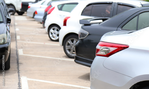 Closeup of rear side of white car and others park in parking area. © Amphon