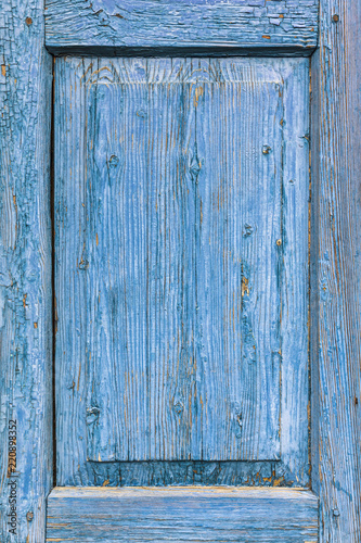 old wooden window shutters covered in blue paint with cracks