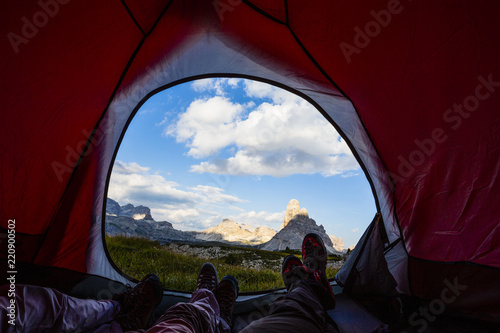 Bivouac at Tre Cime di Lavaredo, family resting in tent, red illuminated tent on pass in Dolomites, Italy