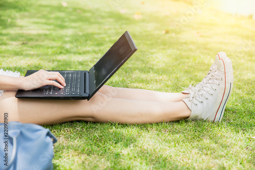 Fototapeta Naklejka Na Ścianę i Meble -  Teen student working with computer laptop outdoor university campus green park concept.