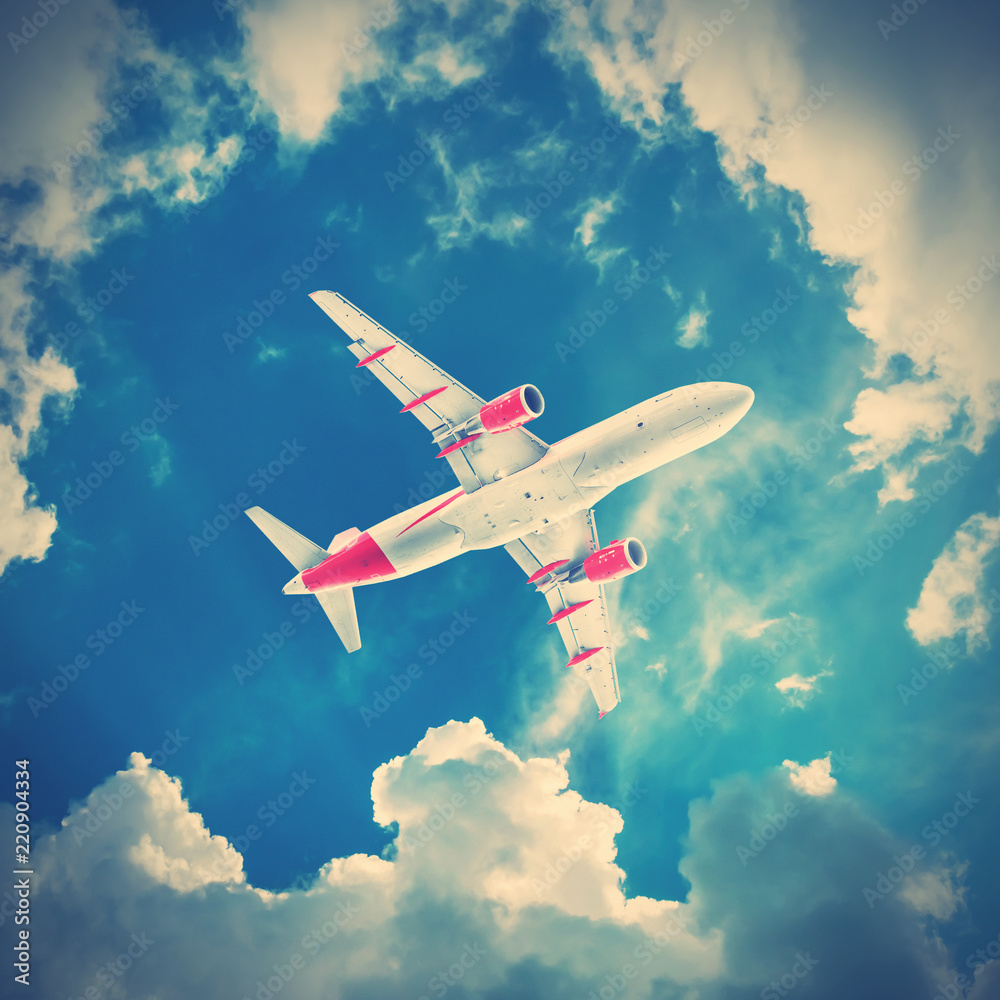 Obraz premium Airplane flying in the cloudy sky, bottom view
