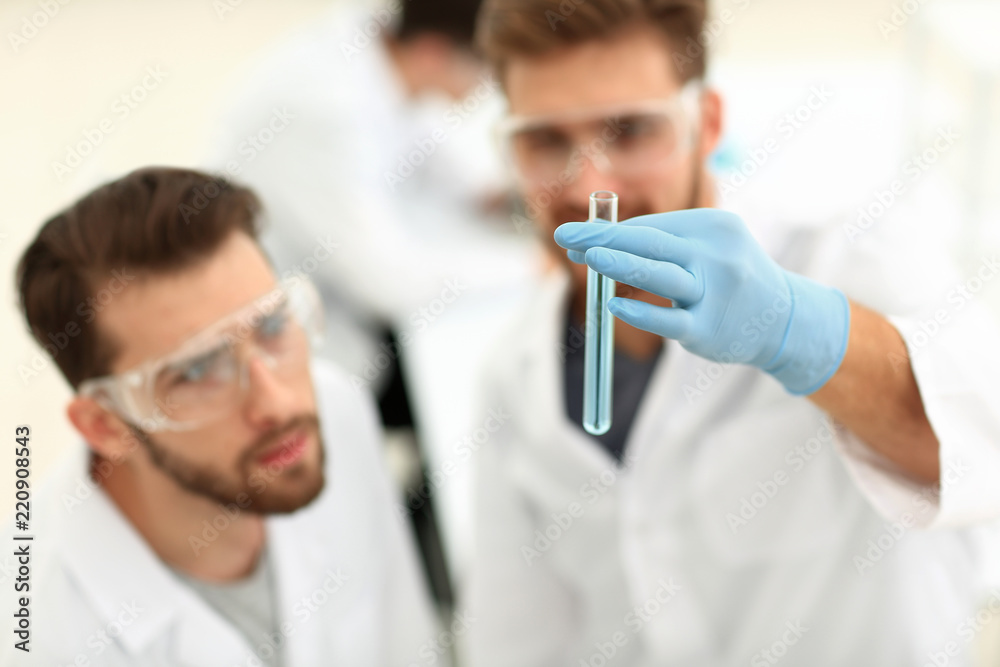 two scientists examining liquid in a test tube two scientists examining liquid in a test tube