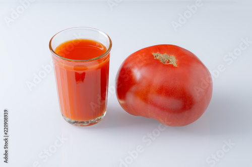 Large tomato and a glass of tomato juice photo