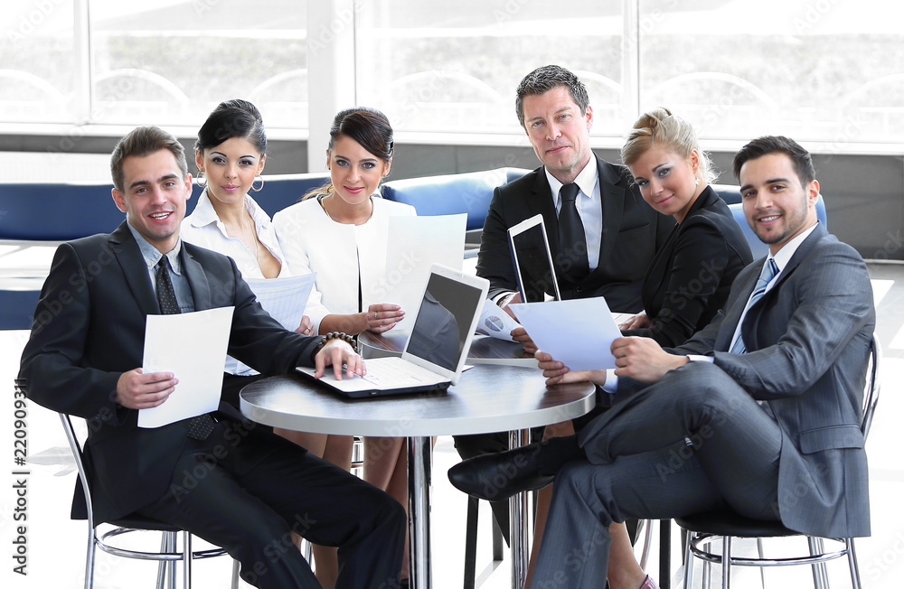 group of business people with documents sitting at a table in the lobby of the Bank. group of business people with documents sitting at a table in the lobby of the Bank.