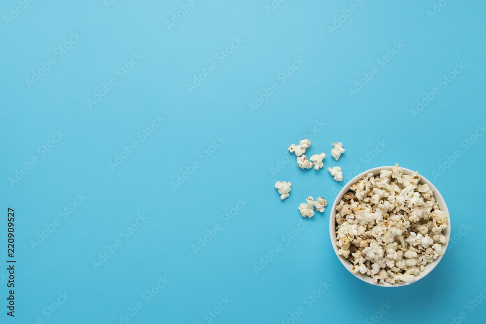 Bowl with popcorn on a blue background. Concept home theater, mo