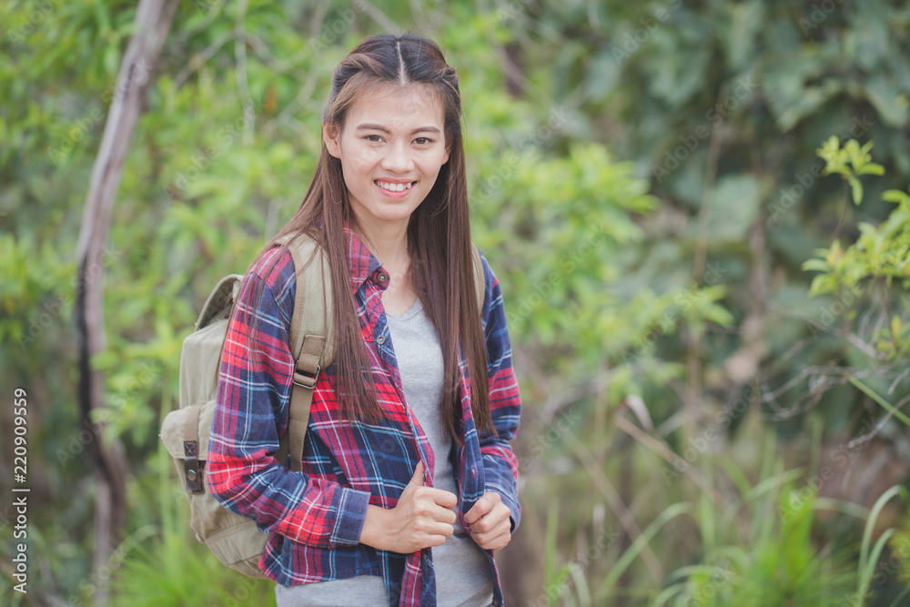 Young traveler with backpack standing on the mountain, Woman hiker on a top of a mountain Young traveler with backpack standing on the mountain, Woman hiker on a top of a mountain