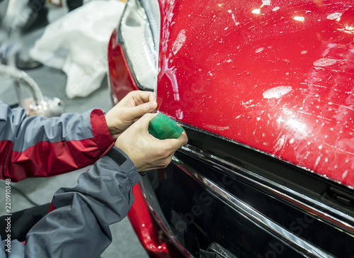 Worker install car paint protection film with spatula © xiaoliangge