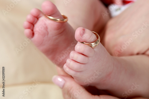 baby foot in mother s hands with care with rings on toes