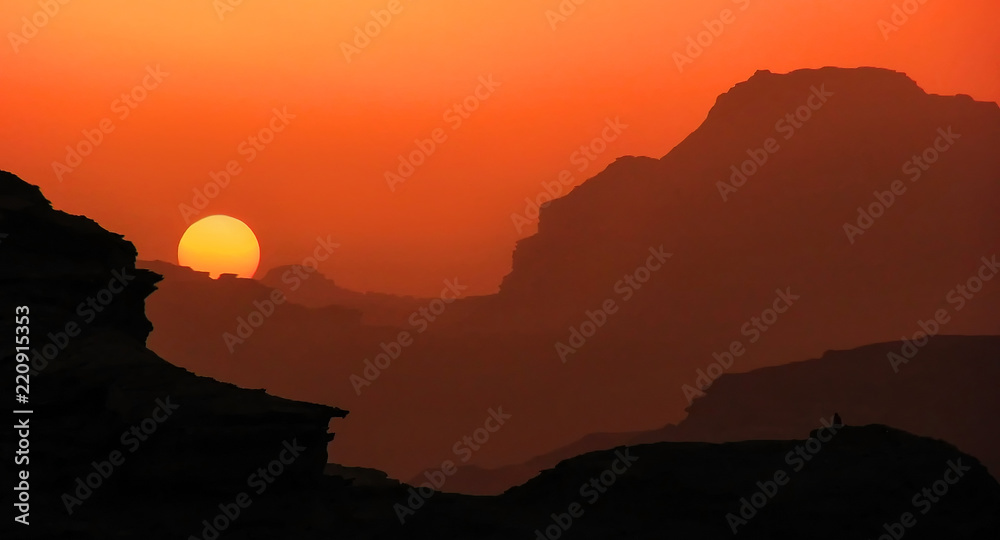 Scenic landscape of sunset above the silhouettes of mountains