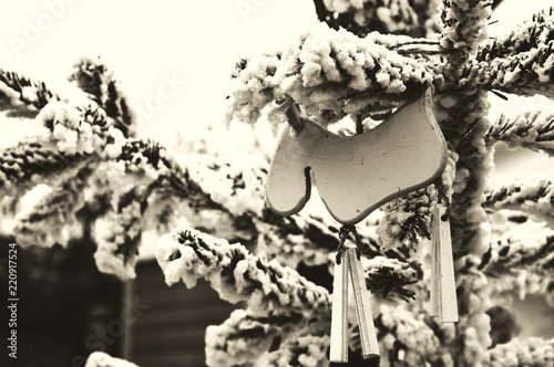 Christmas tree decorated with snow and rustic wooden old times fashioned elk toy. Festive ambiance at traditional Christmas market. Sepia photo. photo