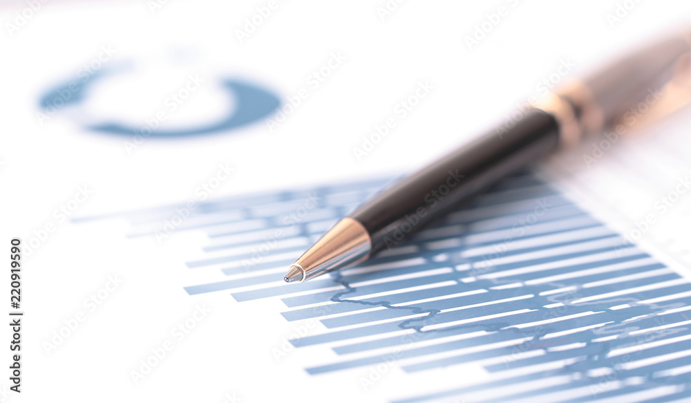 blurred image pen on a sheet with a financial chart blurred image pen on a sheet with a financial chart