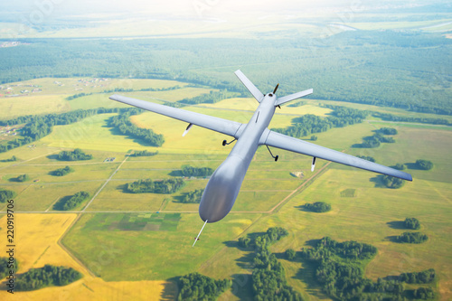 Patrolling unmanned aircraft in the sky above the terrain, fly tracking.