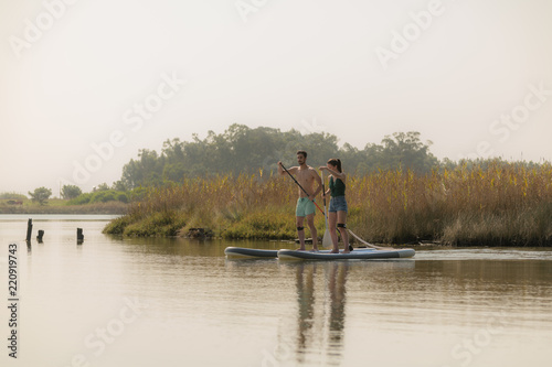 Man and woman stand up paddleboarding