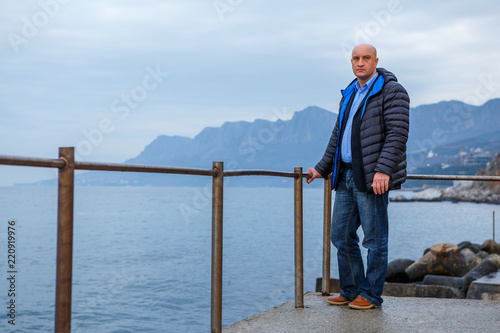 man businessman in a suit standing on the beach