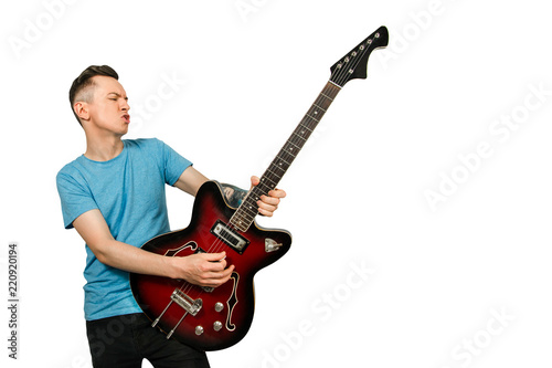 Young guy plays solo on a retro guitar isolated on a white background.