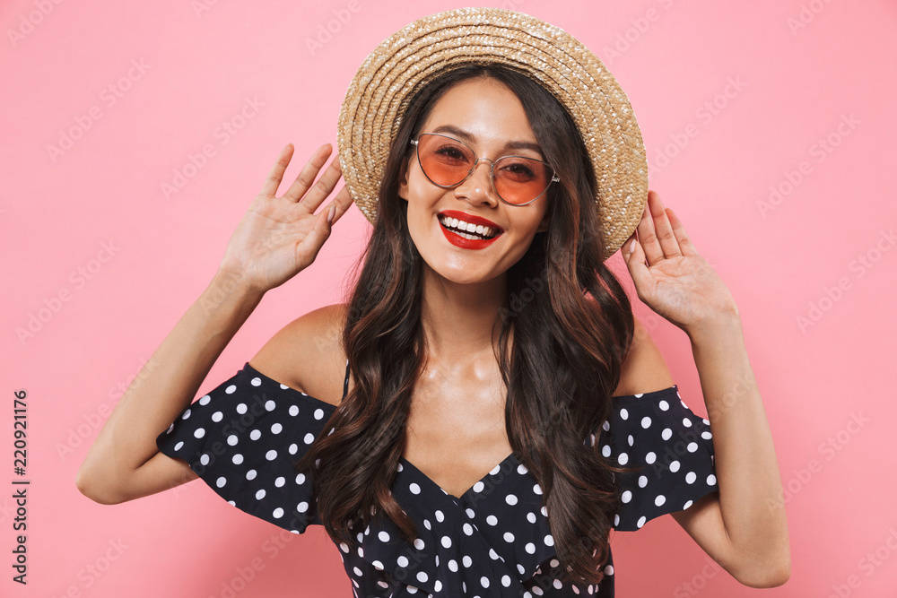 Smiling brunette woman in straw hat and sunglasses posing Smiling brunette woman in straw hat and sunglasses posing