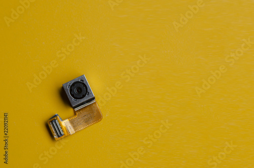 smartphone camera lens part on yellow background photo