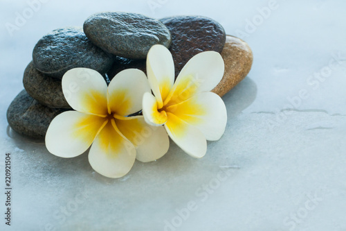 Spa set with flower and stones on white marble table outdoors