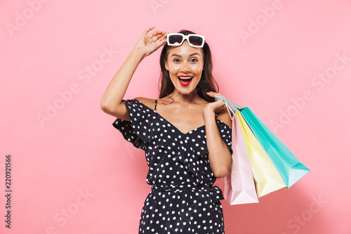 Surprised happy brunette woman in dress take off sunglasses