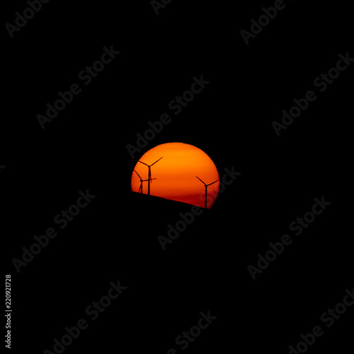 Orange sun and windmill farm at dusk © F.C.G.
