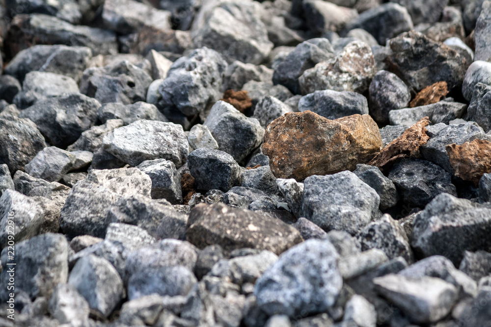 stones average size mostly dark gray and several red, on the ground, texture, background, photo in the street in daylight, close-up stones average size mostly dark gray and several red, on the ground, texture, background, photo in the street in daylight, close-up