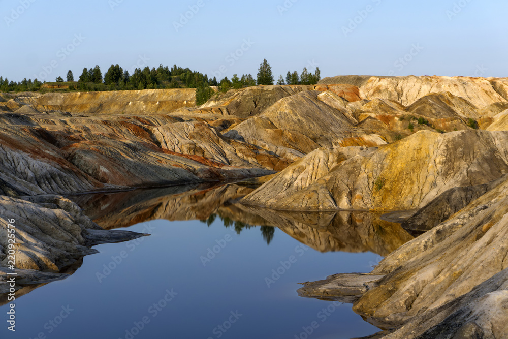 landscape - a fragment of a quarry of kaolin mining with beautiful multicolored slopes and a lake in the foreground landscape - a fragment of a quarry of kaolin mining with beautiful multicolored slopes and a lake in the foreground
