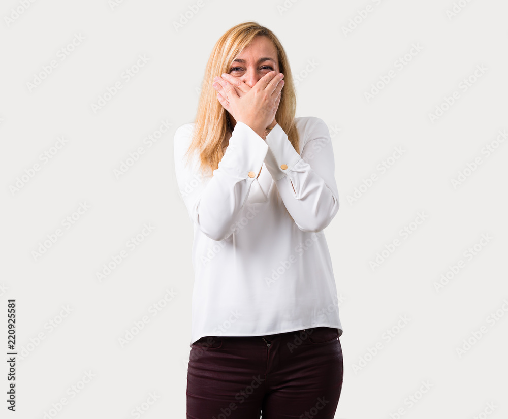 Middle age blonde woman with white shirt covering mouth with both hands for saying something inappropriate. Can not speak on isolated grey background Middle age blonde woman with white shirt covering mouth with both hands for saying something inappropriate. Can not speak on isolated grey background