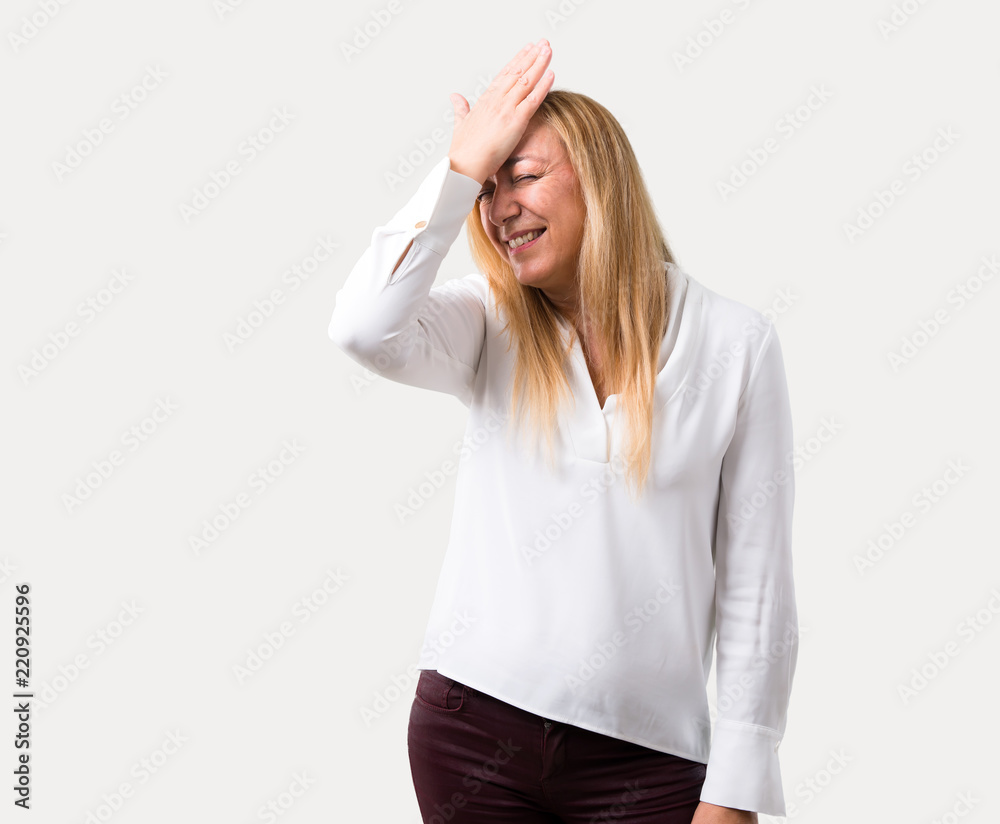 Fototapeta premium Middle age blonde woman with white shirt has just realized something and has intending the solution on isolated grey background