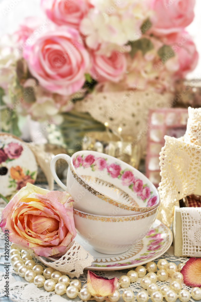 shabby chic style decorations with tea cups, roses and laces