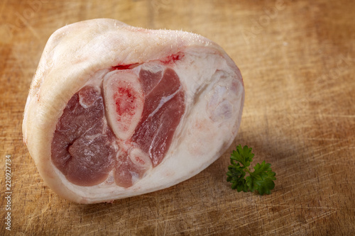 Photos Piece of raw pork shank with parsley leaf