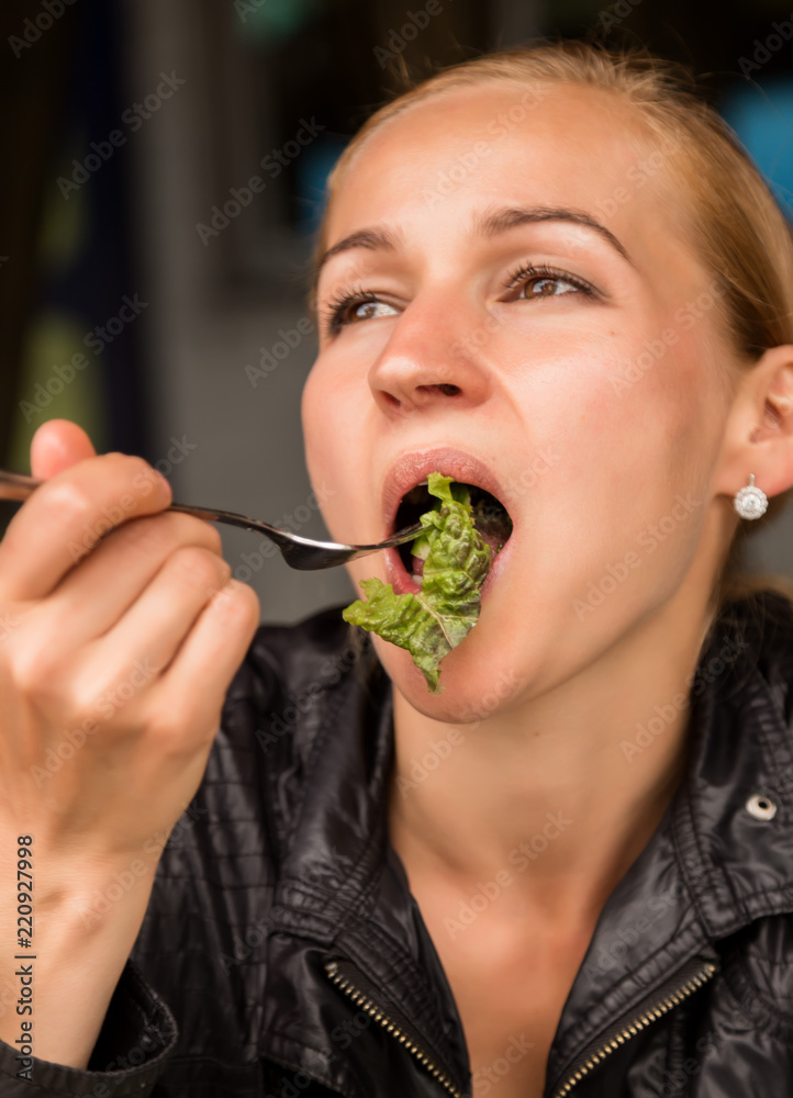 businesswoman eating salad in an outdoor cafe. Healthy lifestyle: girl eating green tasty food businesswoman eating salad in an outdoor cafe. Healthy lifestyle: girl eating green tasty food