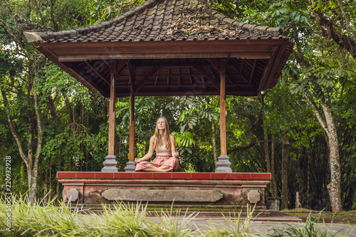 woman practicing yoga in the traditional balinesse gazebo photo