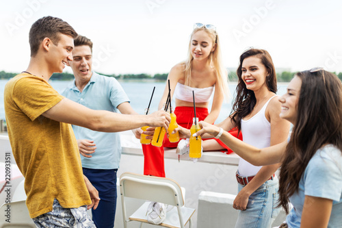 A company of good-looking friends laughing and drinking yellow c