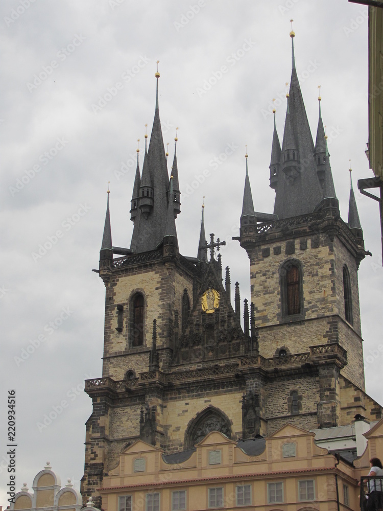 Towers of a cathedral against a cloudy sky background