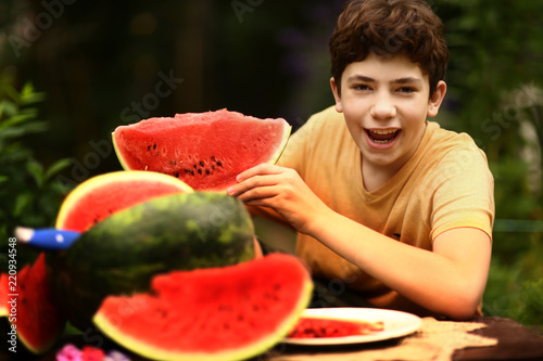 teenager boy with cut water melon close up photo photo