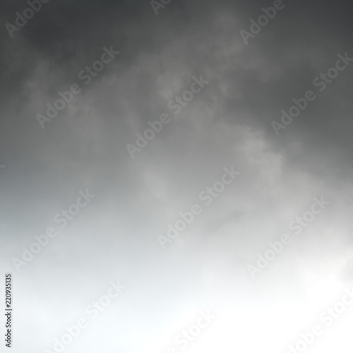 Squared image of moody dark clouds, white copy space at the bottom. Gradient from top to bottom.