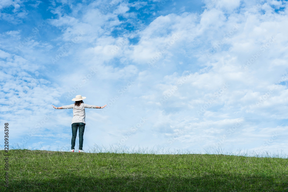 Standing woman raised her hands on the mountain, natural green and beautiful sky. Standing woman raised her hands on the mountain, natural green and beautiful sky.