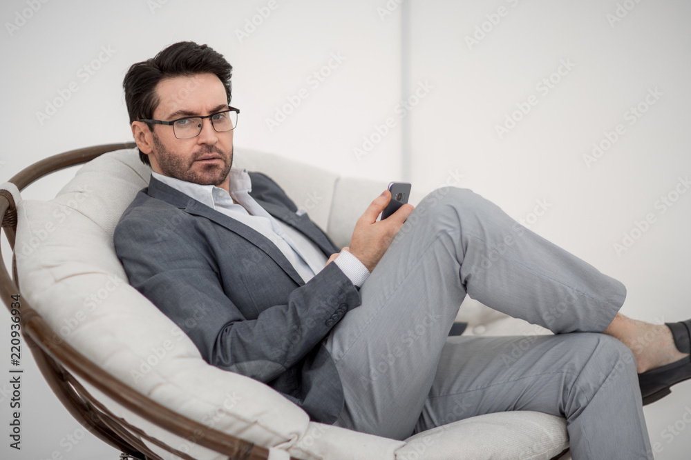 businessman looks at the smartphone screen