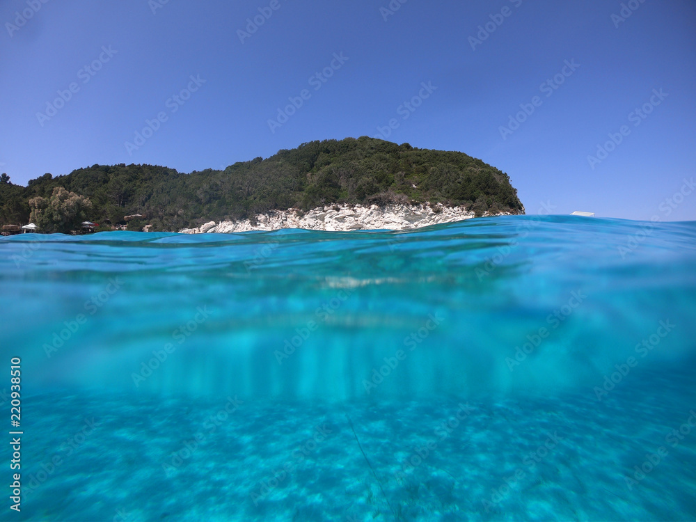 Sea level underwater photo of tropical caribbean paradise turquoise beach in exotic island located in an ocean Sea level underwater photo of tropical caribbean paradise turquoise beach in exotic island located in an ocean
