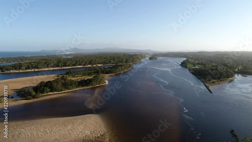 Shallow plains around Nambucca heads town where Nambucca river splits via multiple streams at the entrance to Pacific ocean parallel to sea coast.
 photo