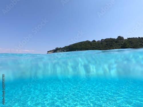 Sea level underwater photo of tropical caribbean paradise turquoise beach in exotic island located in an ocean