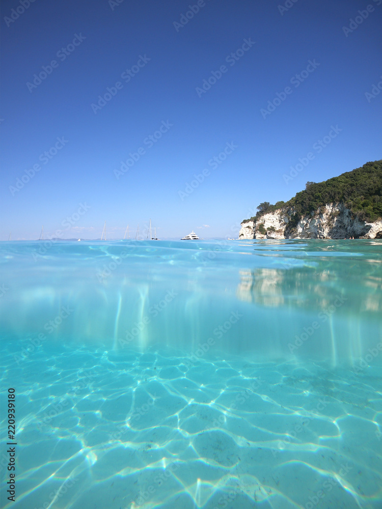 Sea level underwater photo of tropical caribbean paradise turquoise beach in exotic island located in an ocean Sea level underwater photo of tropical caribbean paradise turquoise beach in exotic island located in an ocean