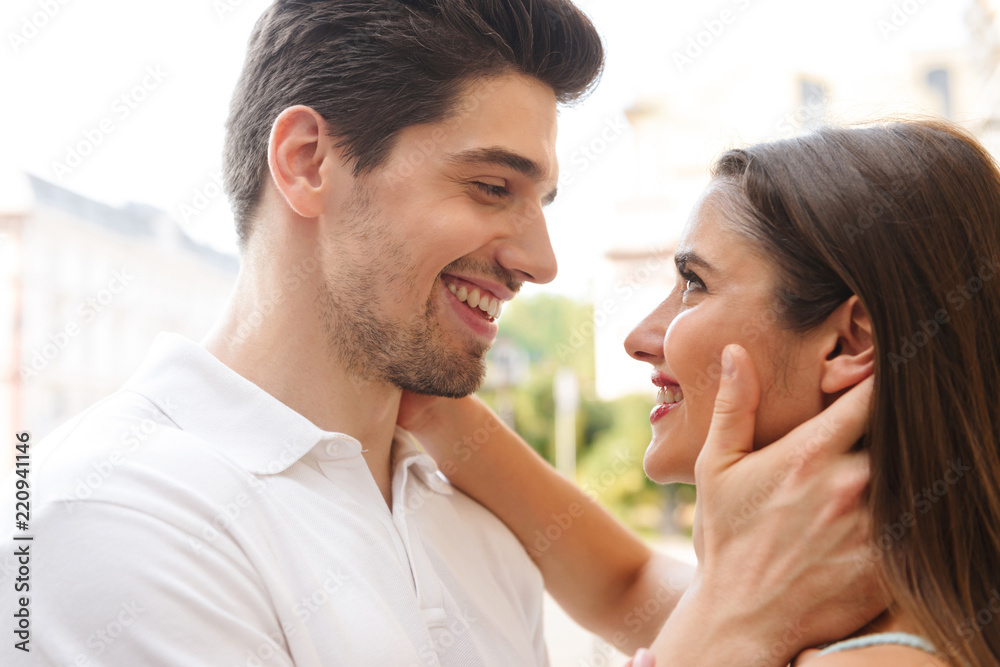 Loving couple walking outdoors while hugging. Loving couple walking outdoors while hugging.