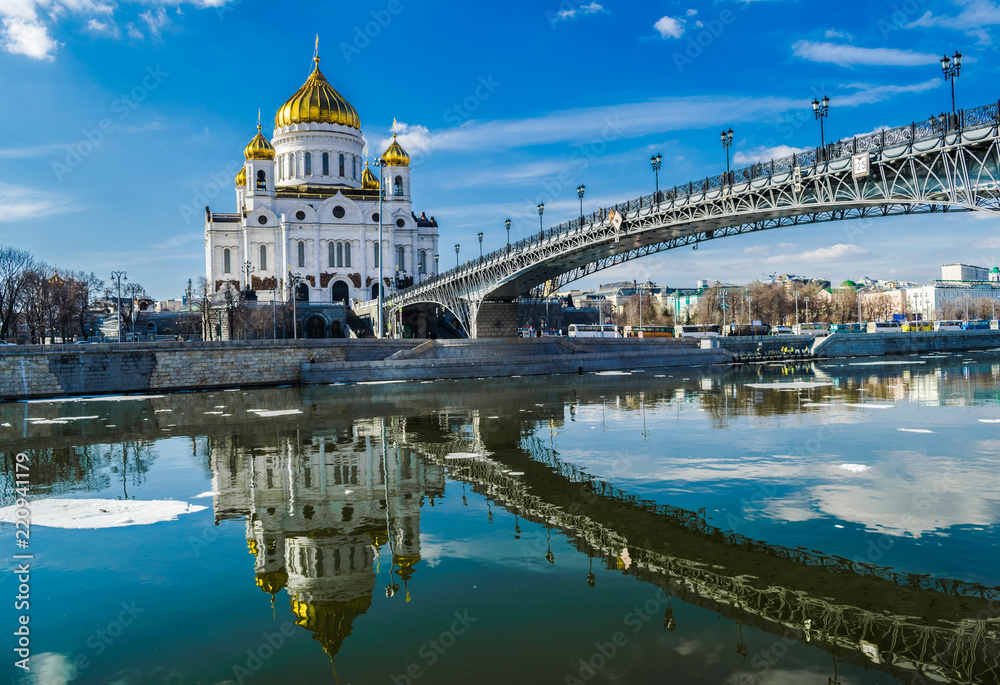 Christ the savior Moscow  orthodox cathedral reflected on the Moscova river with bridge and blue sky
